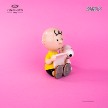 Load image into Gallery viewer, Statuina di Charlie Brown e Snoopy che leggono un foglio.
