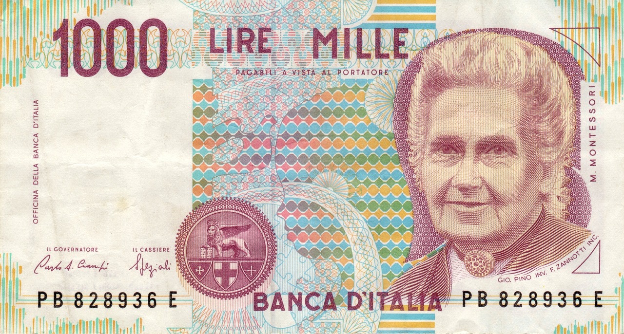Vecchie banconote in lire con ritratto di Maria Montessori, esposte su un tavolo.